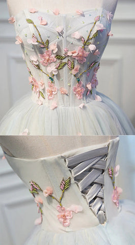 Robe de bal courte en tulle gris mignon, coupe trapèze, décolleté cœur, ornée de fleurs.