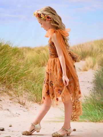 Vestido de niña pequeña hasta la rodilla, de encaje y tul color naranja quemado con bordados. 