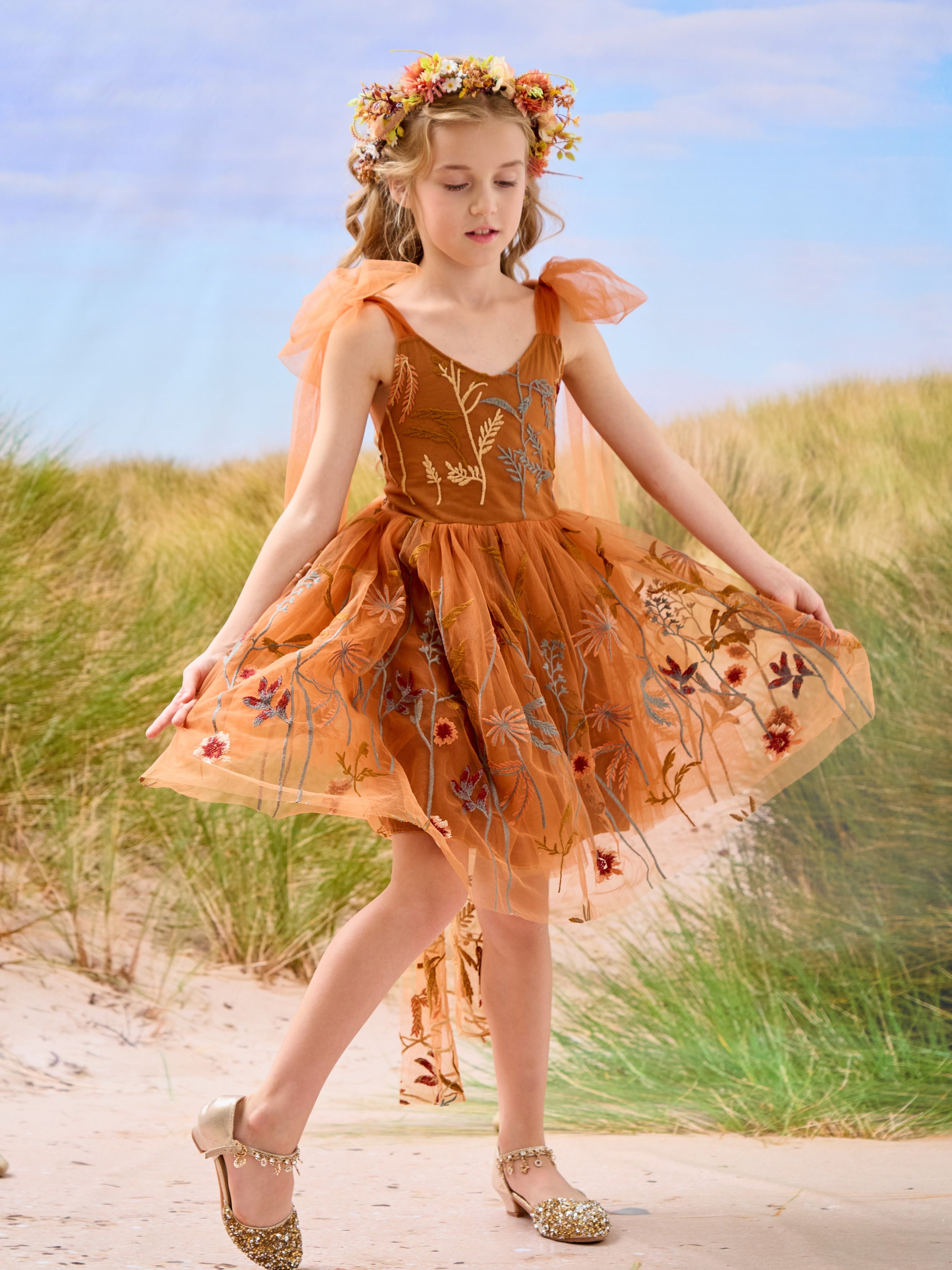 Vestido de niña pequeña hasta la rodilla, de encaje y tul color naranja quemado con bordados. 