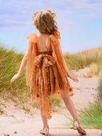 Vestido de niña pequeña hasta la rodilla, de encaje y tul color naranja quemado con bordados. 