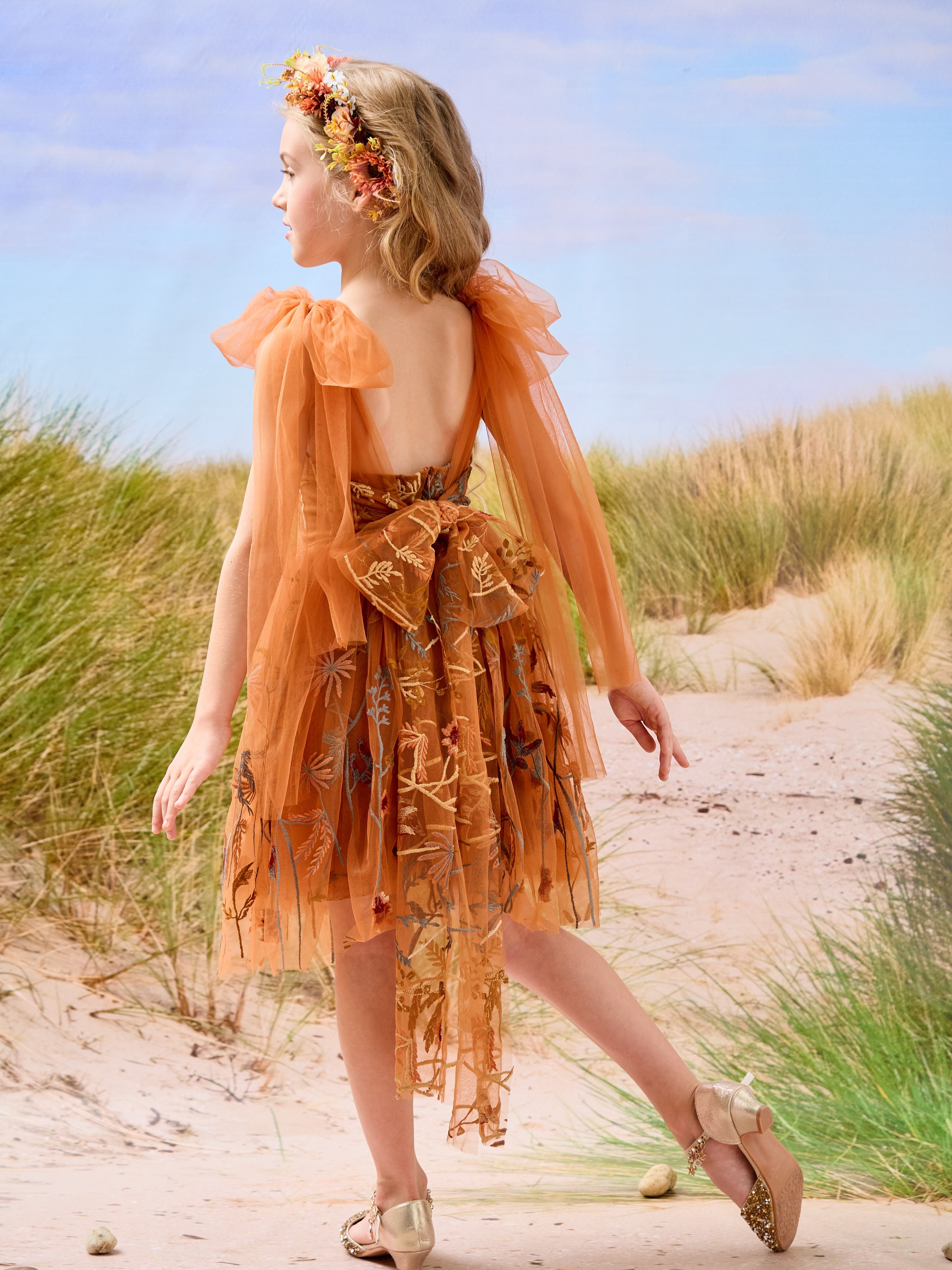Vestido de niña pequeña hasta la rodilla, de encaje y tul color naranja quemado con bordados. 