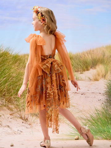 Vestido de niña pequeña hasta la rodilla, de encaje y tul color naranja quemado con bordados. 