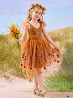 Vestido de niña pequeña hasta la rodilla, de encaje y tul color naranja quemado con bordados. 