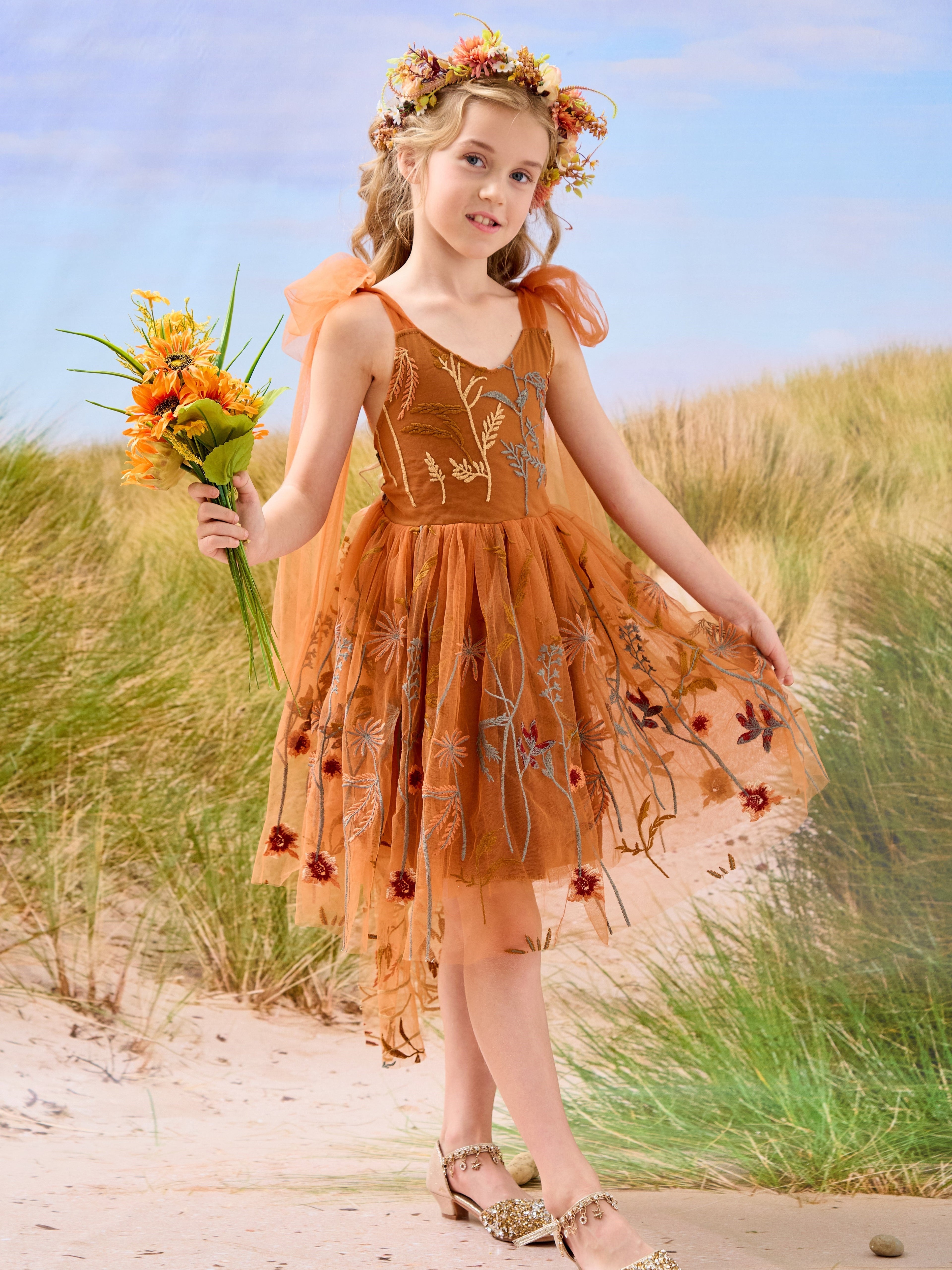 Vestido de niña pequeña hasta la rodilla, de encaje y tul color naranja quemado con bordados. 