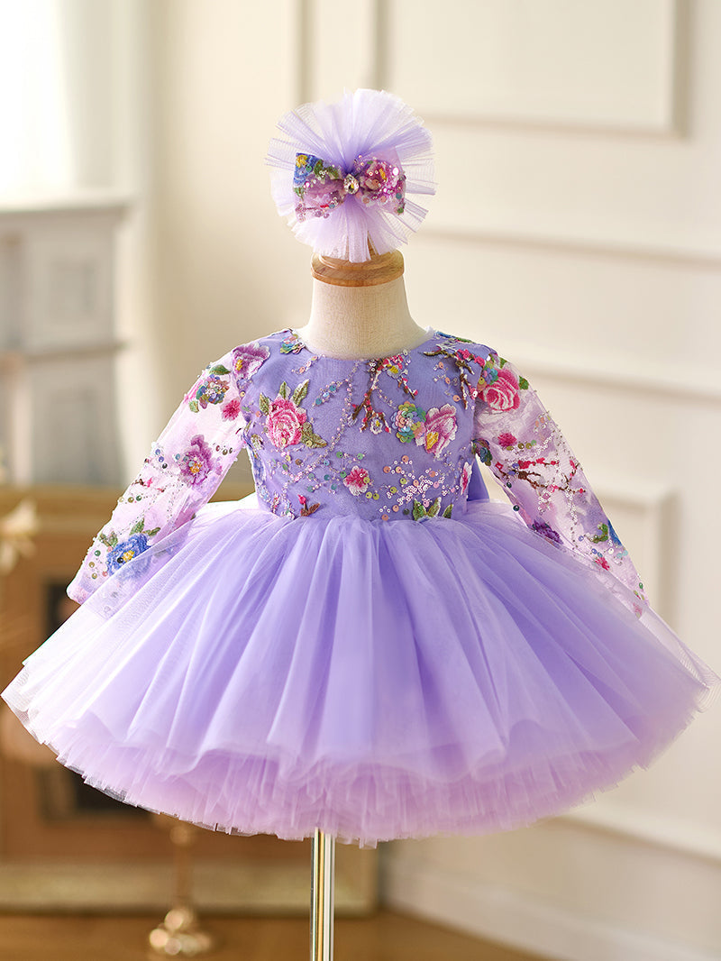 Vestido de bebé niña color lila con lentejuelas, mangas largas con volantes y largo hasta la rodilla 