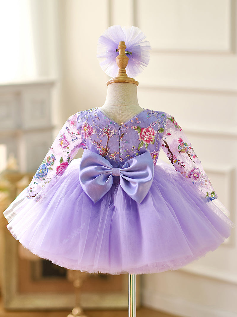Vestido de bebé niña color lila con lentejuelas, mangas largas con volantes y largo hasta la rodilla 