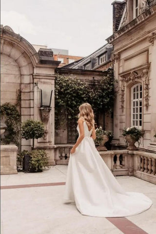Robe de mariée longue trapèze en satin simple, sans manches, avec fente et col en V.