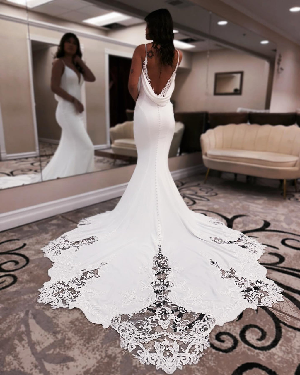 Robe de mariée sirène de créateur, bretelles spaghetti, sans manches, ornée d'appliqués en satin et dentelle, dos nu et traîne.