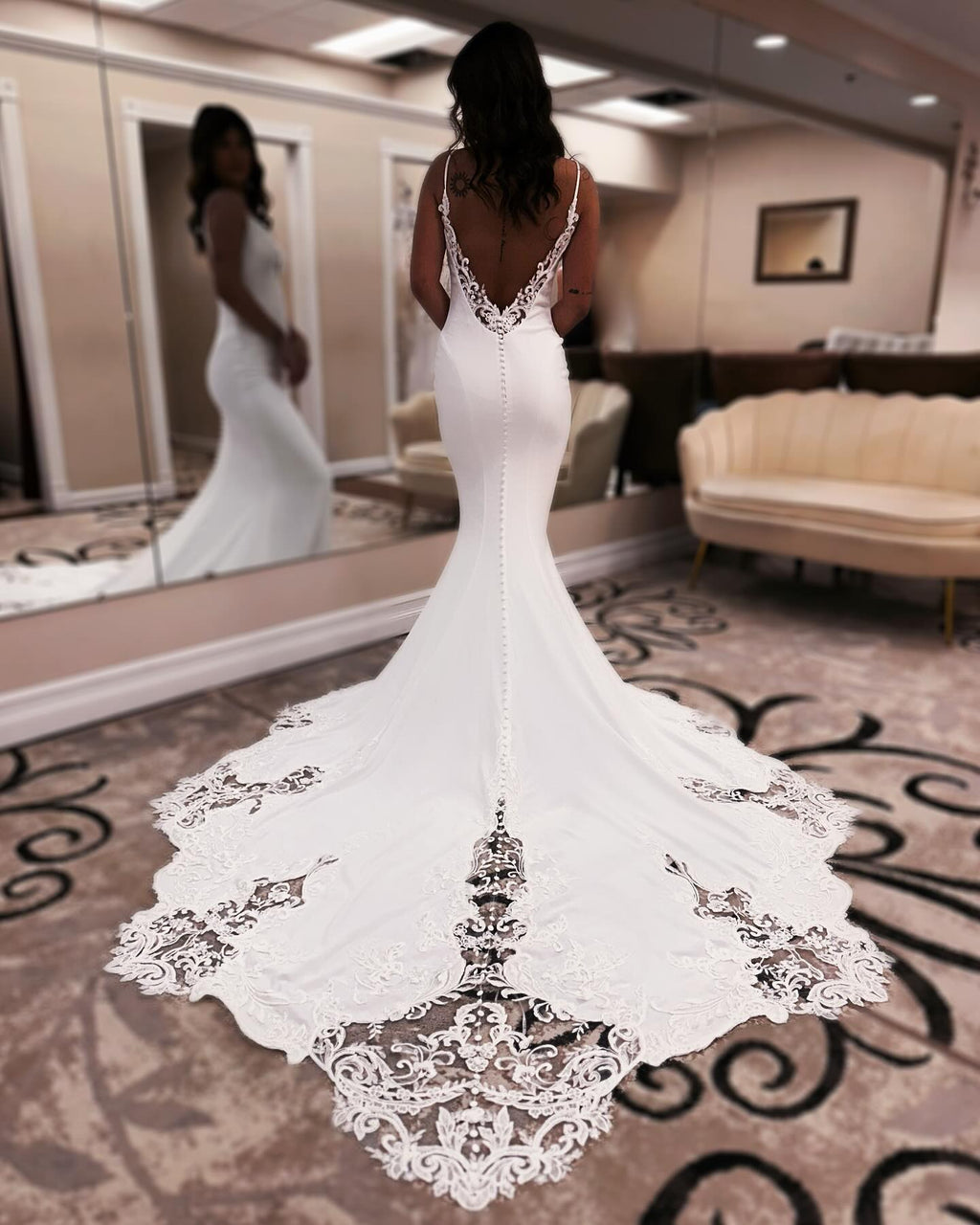 Robe de mariée sirène de créateur, bretelles spaghetti, sans manches, ornée d'appliqués en satin et dentelle, dos nu et traîne.