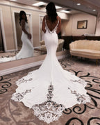 Robe de mariée sirène de créateur, bretelles spaghetti, sans manches, ornée d'appliqués en satin et dentelle, dos nu et traîne.