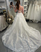 Robe de mariée blanche de créateur, coupe trapèze, bretelles spaghetti, sans manches, en tulle et dentelle.