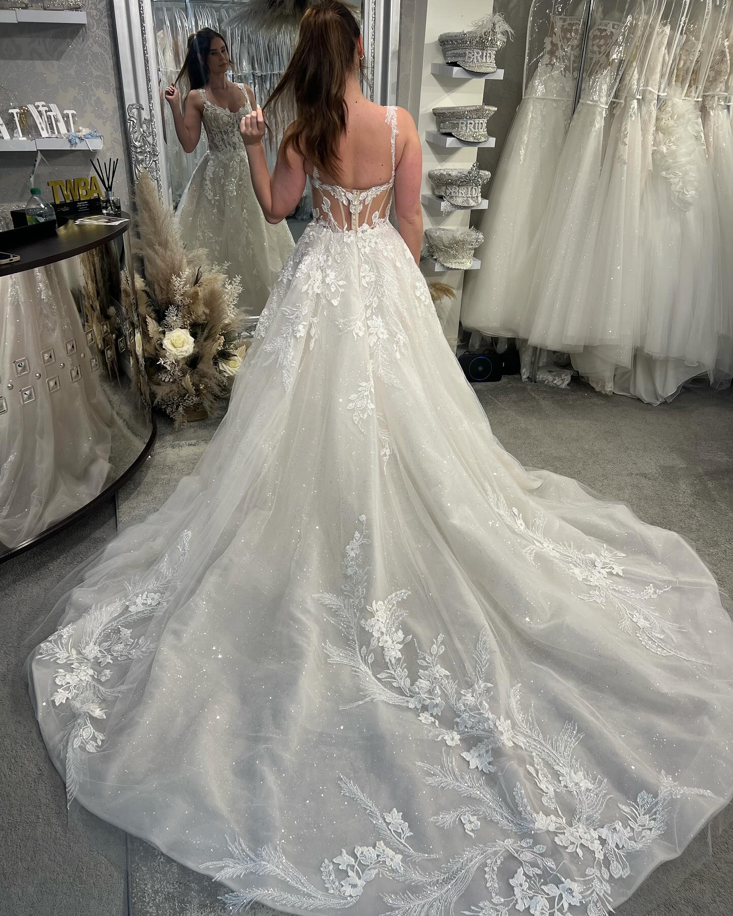 Robe de mariée blanche de créateur, coupe trapèze, bretelles spaghetti, sans manches, en tulle et dentelle.