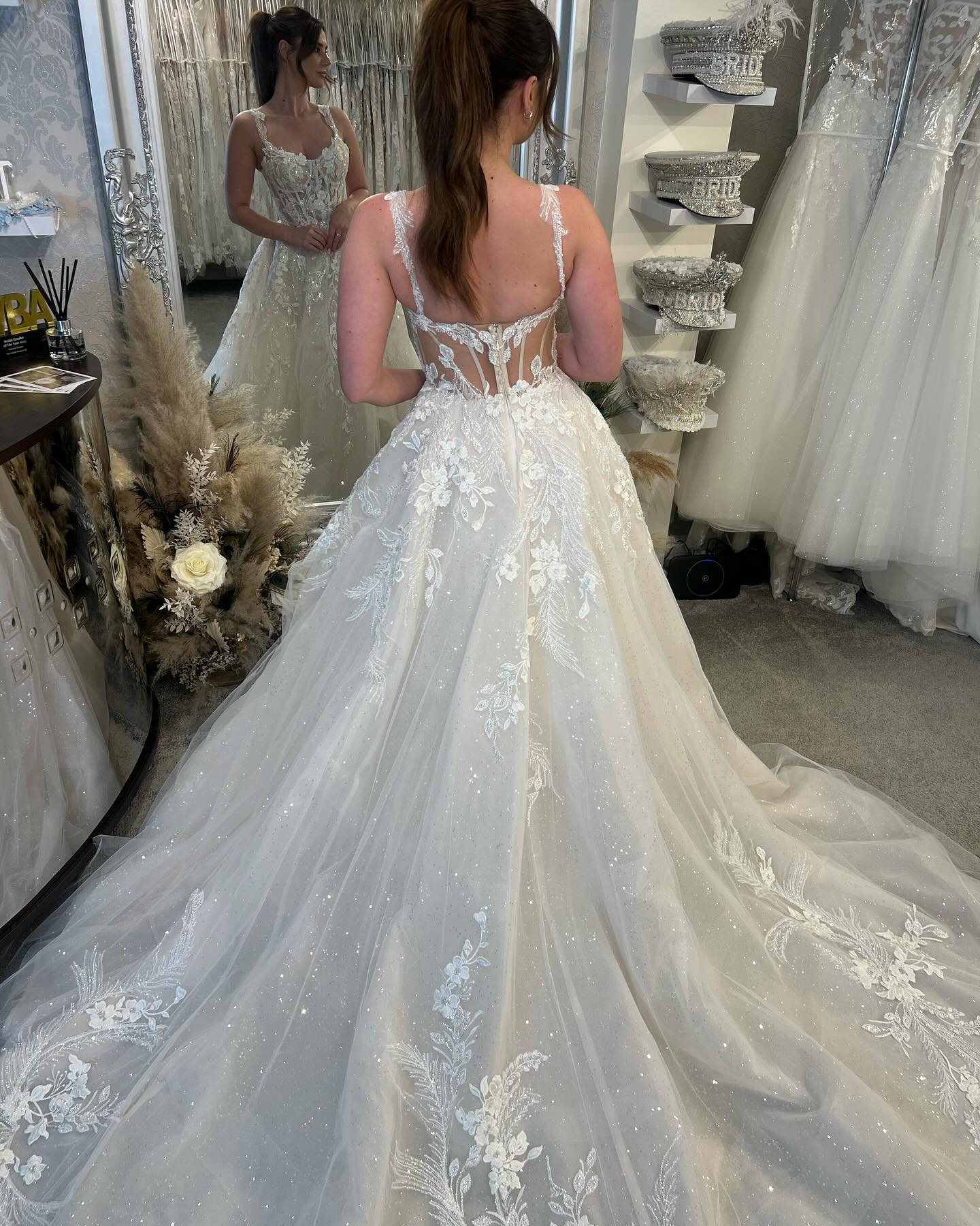 Robe de mariée blanche de créateur, coupe trapèze, bretelles spaghetti, sans manches, en tulle et dentelle.