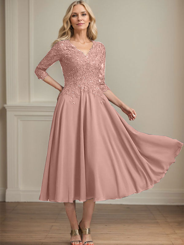 Vestido de corte A, escote en V, largo hasta la rodilla, de gasa, encaje, con lentejuelas y pedrería para la madre de la novia. 