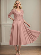 Vestido de corte A, escote en V, largo hasta la rodilla, de gasa, encaje, con lentejuelas y pedrería para la madre de la novia. 