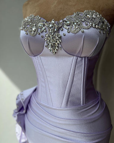 Elegante vestido de fiesta de corte columna con escote corazón, pedrería, volantes y abertura.