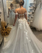 Elegante vestido de novia largo de corte A con escote corazón, hombros descubiertos y apliques brillantes