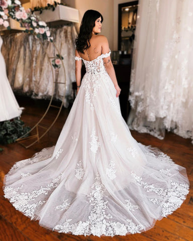 Elegante vestido de novia largo de corte A, sin mangas, de encaje, con tirantes y abertura.