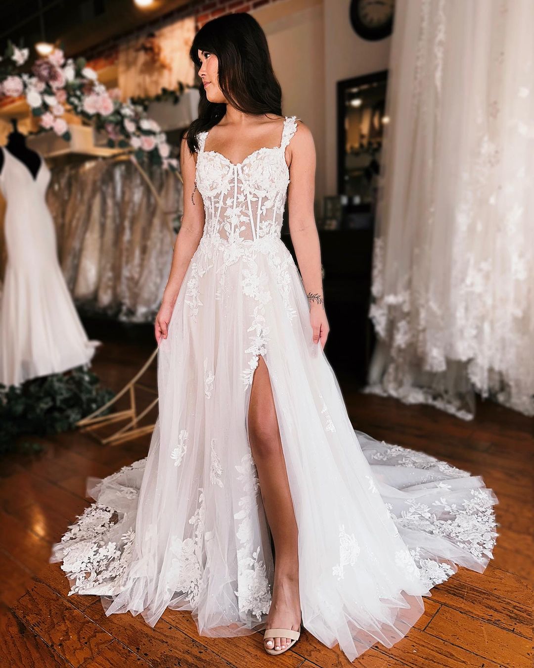 Robe de mariée élégante en dentelle, longue, à bretelles et sans manches, avec fente.