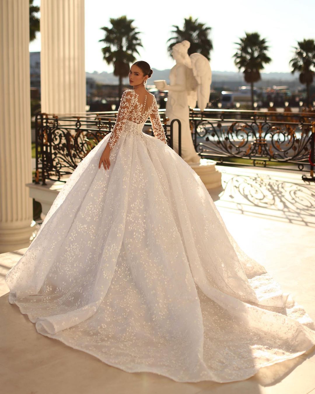 Elegante vestido de novia largo de encaje color marfil con escote en V y mangas largas.