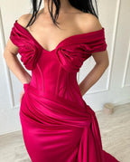 Elegante vestido largo de sirena sin mangas con escote en V y hombros descubiertos, de satén fucsia.