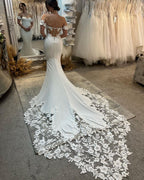 Elegante vestido de novia largo blanco de corte sirena con hombros descubiertos, apliques y cola