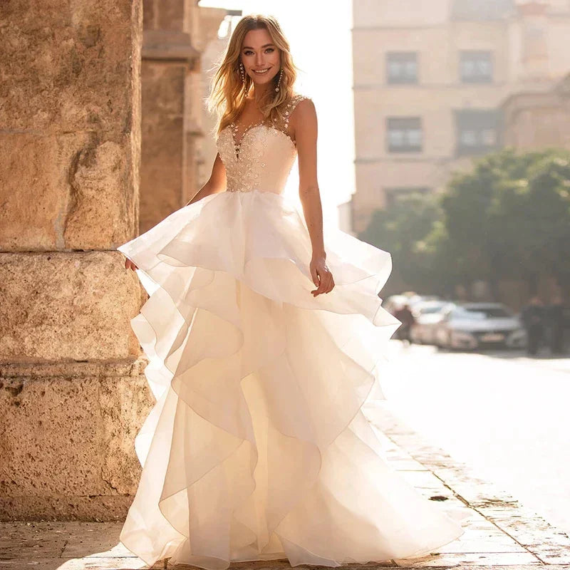 Robes de mariée élégantes à décolleté cœur 2024, ornées d'appliqués floraux, sans manches, dos illusion, à volants et traîne courte.
