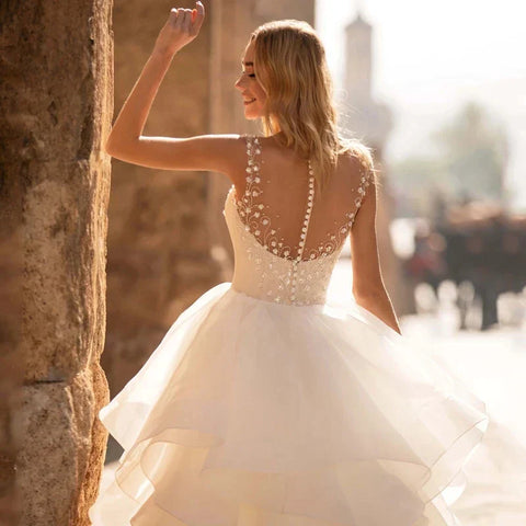 Robes de mariée élégantes à décolleté cœur 2024, ornées d'appliqués floraux, sans manches, dos illusion, à volants et traîne courte.
