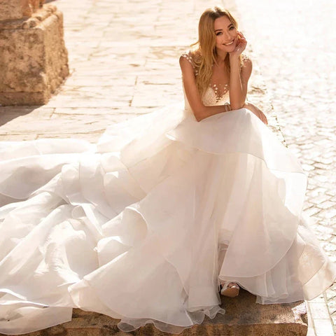 Robes de mariée élégantes à décolleté cœur 2024, ornées d'appliqués floraux, sans manches, dos illusion, à volants et traîne courte.