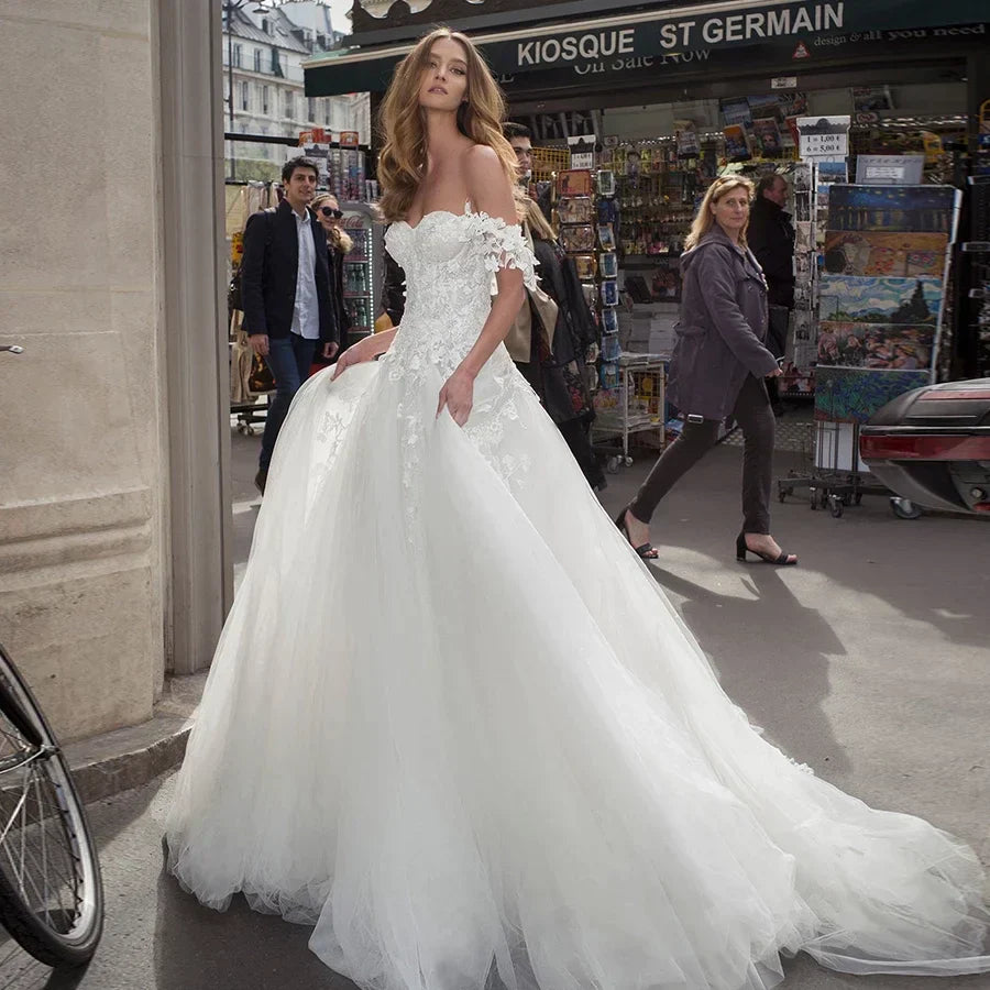 Vestidos de novia elegantes de tul blanco con escote corazón y hombros descubiertos, apliques personalizados y espalda descubierta.