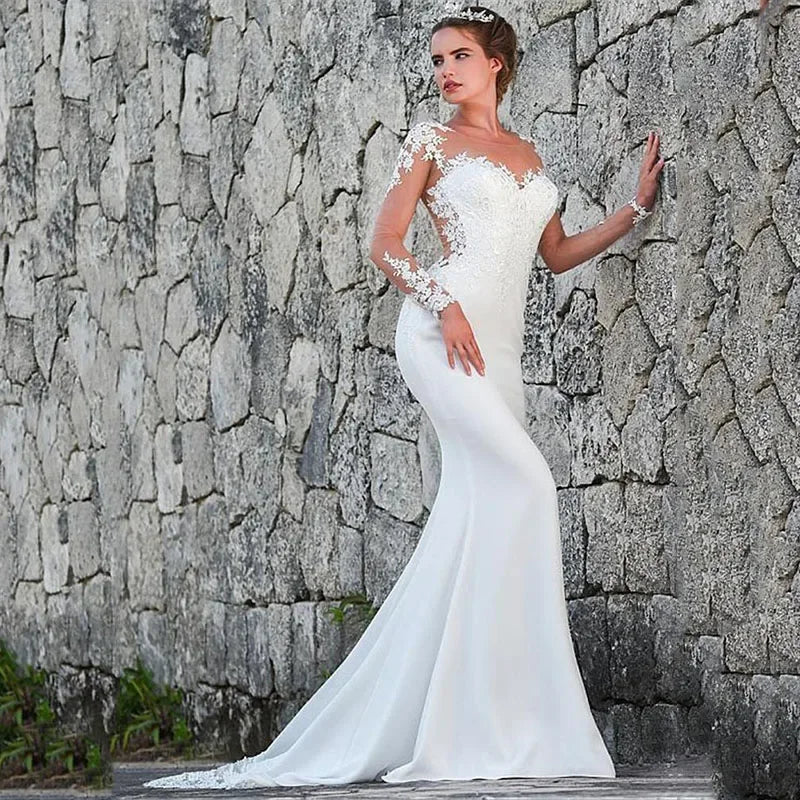 Robe de mariée blanche élégante à col rond et manches longues, ornée de cristaux et de perles, coupe sirène avec traîne. 