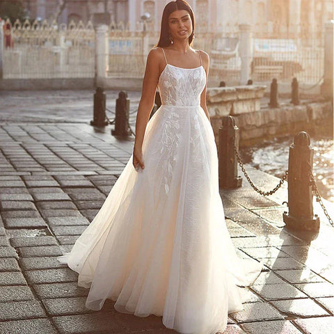Exquisito vestido de novia sin mangas con hombros descubiertos, estilo princesa, con cuello cuadrado clásico de encaje.