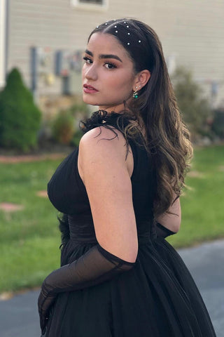 Vestido largo de tul rosa con espalda descubierta, escote en V pronunciado y detalles de plumas.