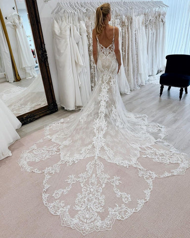 Fabuloso vestido de novia blanco de sirena, con tirantes finos, tul, encaje y cola, sin mangas y con apliques.