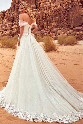 Robe de mariée en tulle à épaules dénudées et coupe trapèze, avec traîne balayée. 