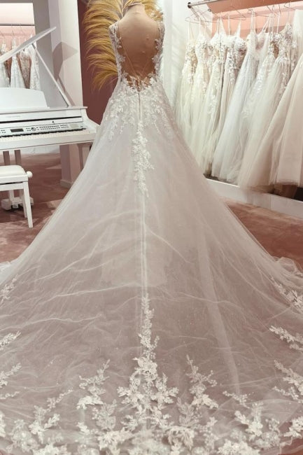 Robe de mariée longue en tulle et dentelle, coupe trapèze, col en V et traîne.