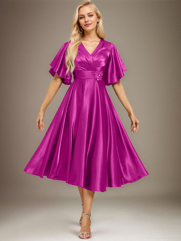 Vestido de novia de satén elástico, corte en A, escote en V, largo hasta la rodilla, con cuentas y pliegues. 