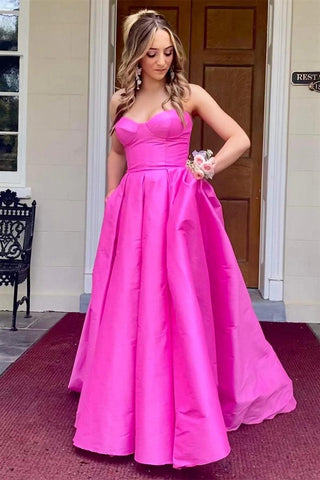Vestido largo de noche de satén fucsia sin tirantes con bolsillos