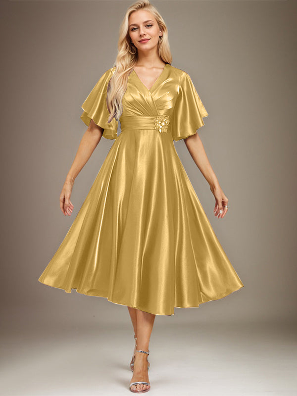 Vestido de novia de satén elástico, corte en A, escote en V, largo hasta la rodilla, con cuentas y pliegues. 