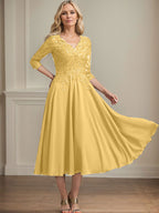 Vestido de corte A, escote en V, largo hasta la rodilla, de gasa, encaje, con lentejuelas y pedrería para la madre de la novia. 
