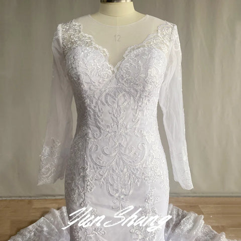 Precioso vestido de novia de sirena de encaje de manga larga, con tul, cola catedral, escote en V, apliques y espalda abotonada. 