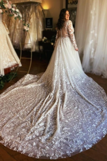Magnifique robe de mariée longue en dentelle, coupe trapèze, col V, manches longues et traîne.