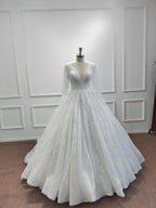 Precioso vestido de novia largo de corte princesa, con escote en V, lentejuelas brillantes y mangas.