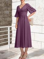 Vestido de novia de gasa de encaje, corte en A, escote en V y largo hasta la rodilla, con pliegues.