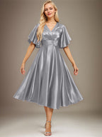 Vestido de novia de satén elástico, corte en A, escote en V, largo hasta la rodilla, con cuentas y pliegues. 