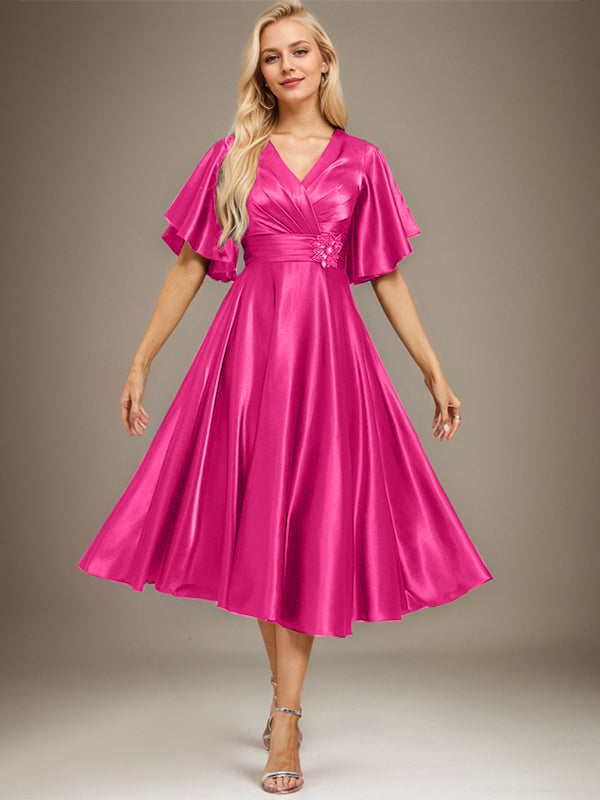 Vestido de novia de satén elástico, corte en A, escote en V, largo hasta la rodilla, con cuentas y pliegues. 