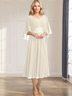 Robe de mariée trapèze en mousseline de soie, longueur thé, col en V, ornée de sequins plissés, d'appliques de dentelle et de perles. 