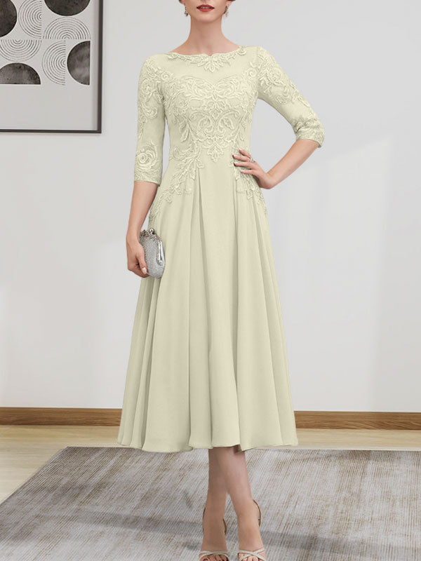 Robe de mariée trapèze en mousseline de soie et dentelle, longueur thé, ornée de perles et de sequins, avec décolleté en A et effet illusion.