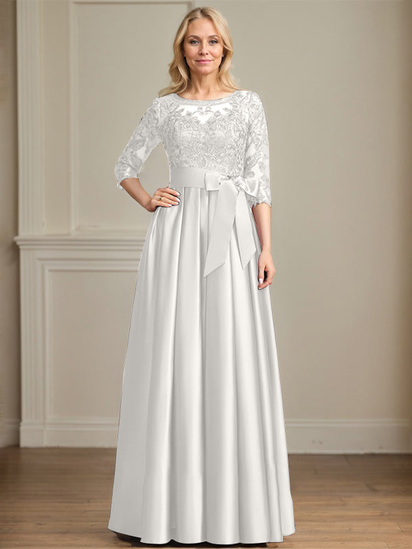 Vestido de novia corte A, escote ilusión, largo hasta el suelo, de satén y encaje, con lazo de lentejuelas. 