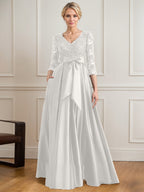 Vestido de novia de satén con encaje, corte en A, escote en V y largo hasta el suelo, con lazo de lentejuelas. 